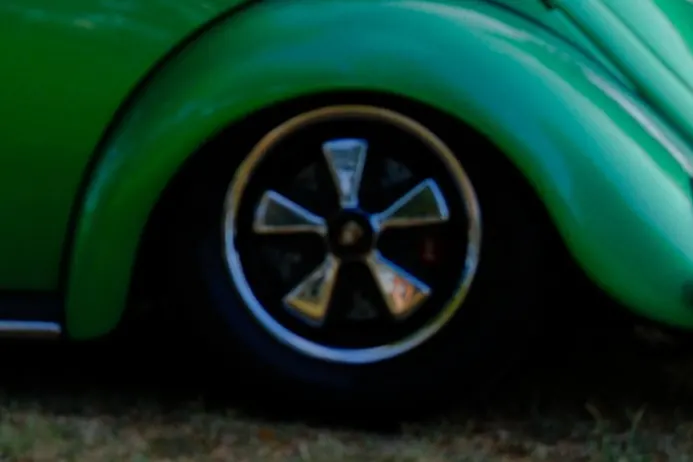Close-up of the green Beetle's rear fender and five-spoke wheel
